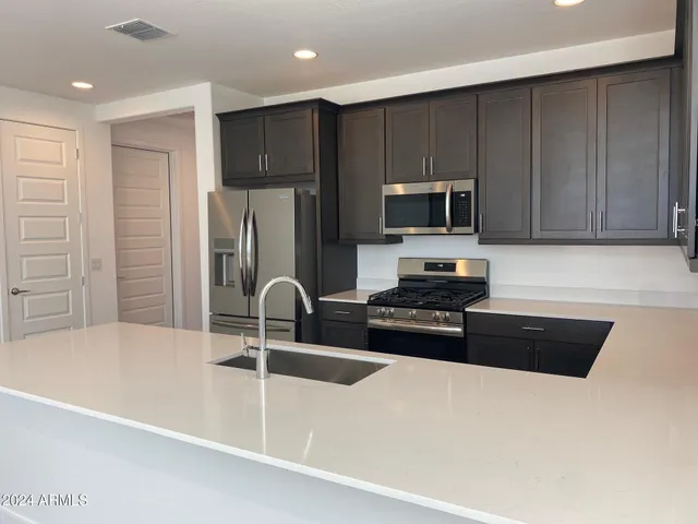 a kitchen with a refrigerator and a stove top oven