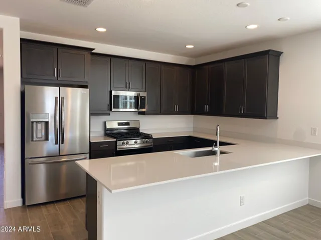 a kitchen with granite countertop a refrigerator and a sink