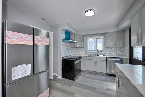 a kitchen with a stove a sink and a refrigerator