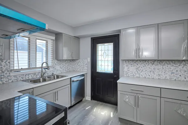 a kitchen with a sink cabinets appliances and a window