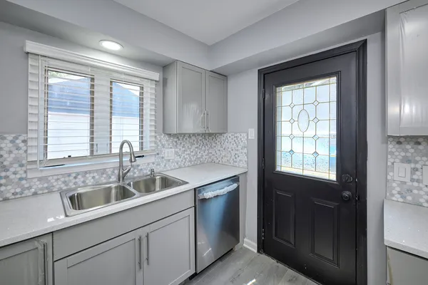 a kitchen with a sink a window and cabinets