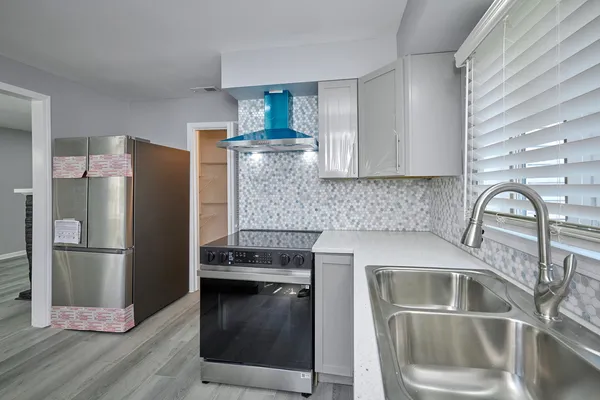 a kitchen with a refrigerator sink and cabinets