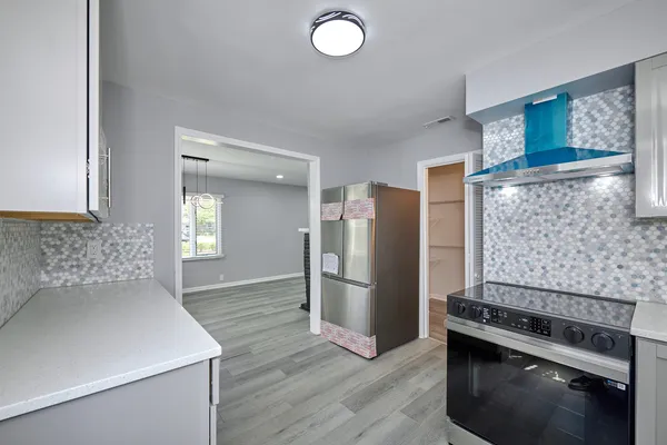 a kitchen with a refrigerator and a stove top oven