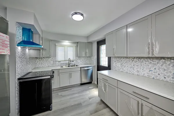 a kitchen that has a sink and a stove in it