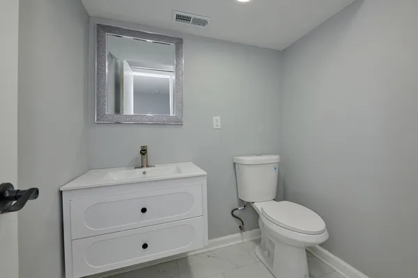 a bathroom with a toilet sink and mirror