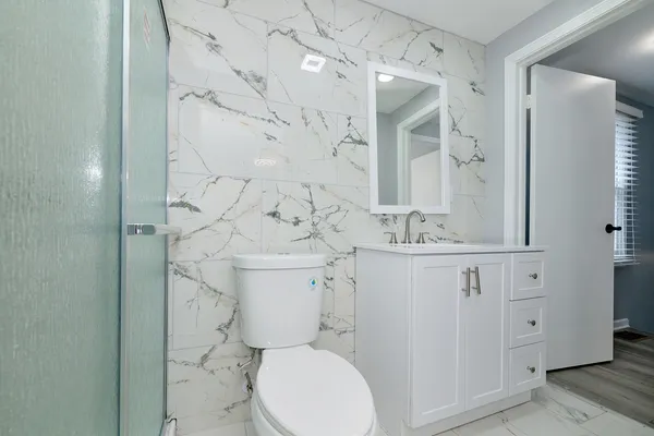 a white toilet sitting next to a bathroom sink