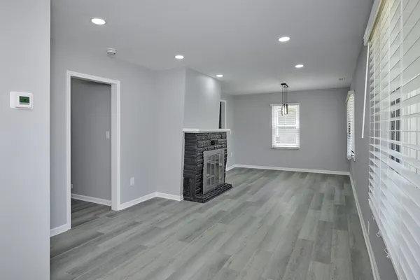 an empty room with wooden floor and windows