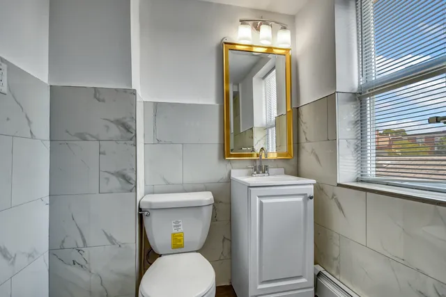a bathroom with a toilet sink and mirror
