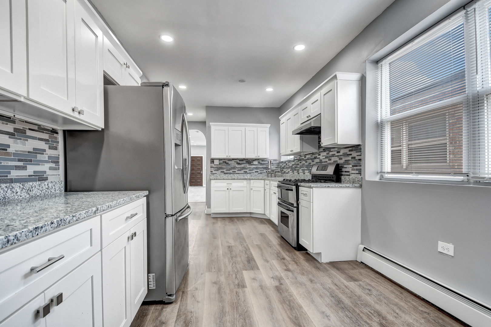 7409 West 63rd Place Summit, IL 60501 - Photo 5 of 18 a kitchen with a refrigerator and white cabinets