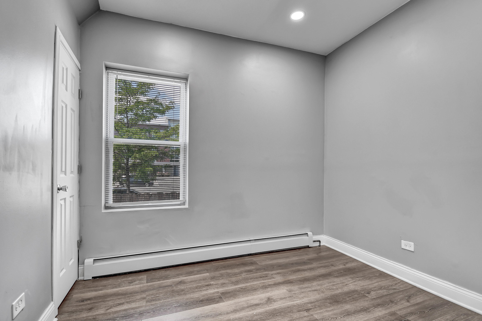 7409 West 63rd Place Summit, IL 60501 - Photo 10 of 18 an empty room with wooden floor and windows