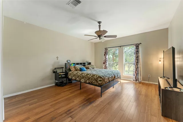 a bedroom with a bed and wooden floor