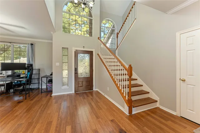 a view of an entryway with wooden floor windows and a livingroom