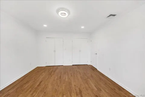 a view of a room with wooden floor and white walls