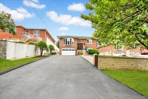 a view of a house with a yard and a large tree