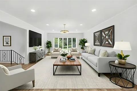 a living room with furniture a flat screen tv and a large window