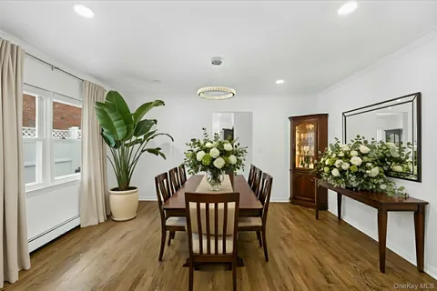 a dining room with furniture potted plants and wooden floor