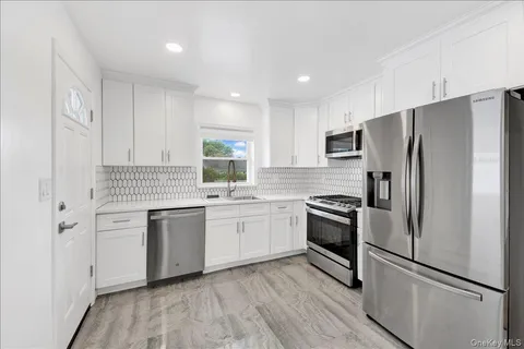 a kitchen with cabinets stainless steel appliances and window