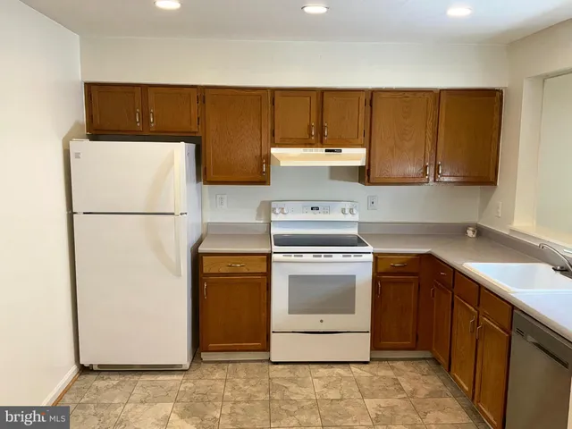 a kitchen with a refrigerator sink and cabinets