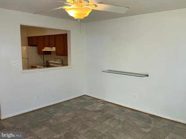 an empty room with a mirror and a fan