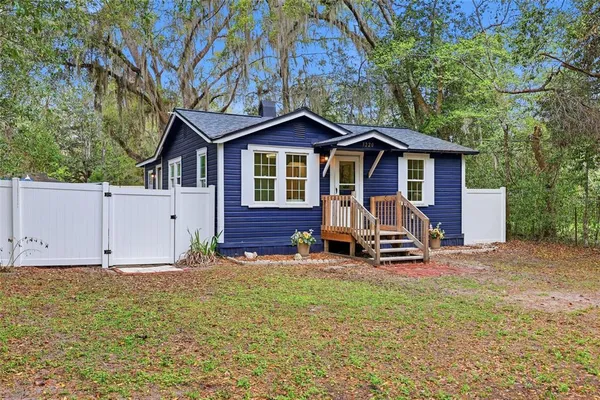 a view of a house with a yard and wooden fence