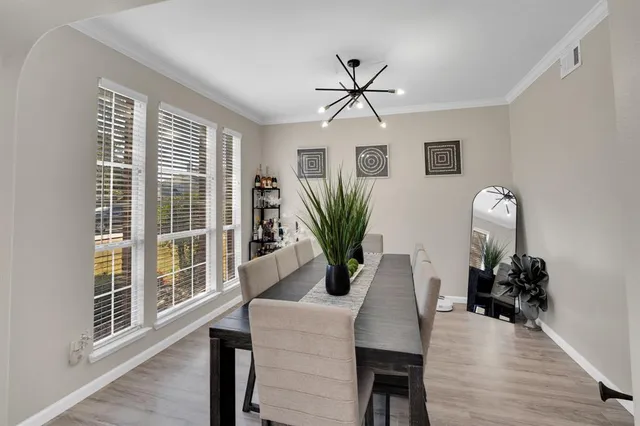 a dining room with furniture potted plants and wooden floor