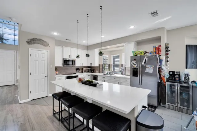 a kitchen with granite countertop a table chairs stove and white cabinets