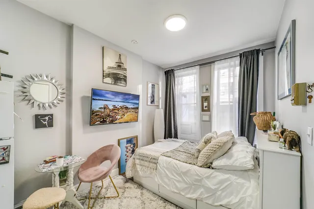 a bedroom with furniture and a large window