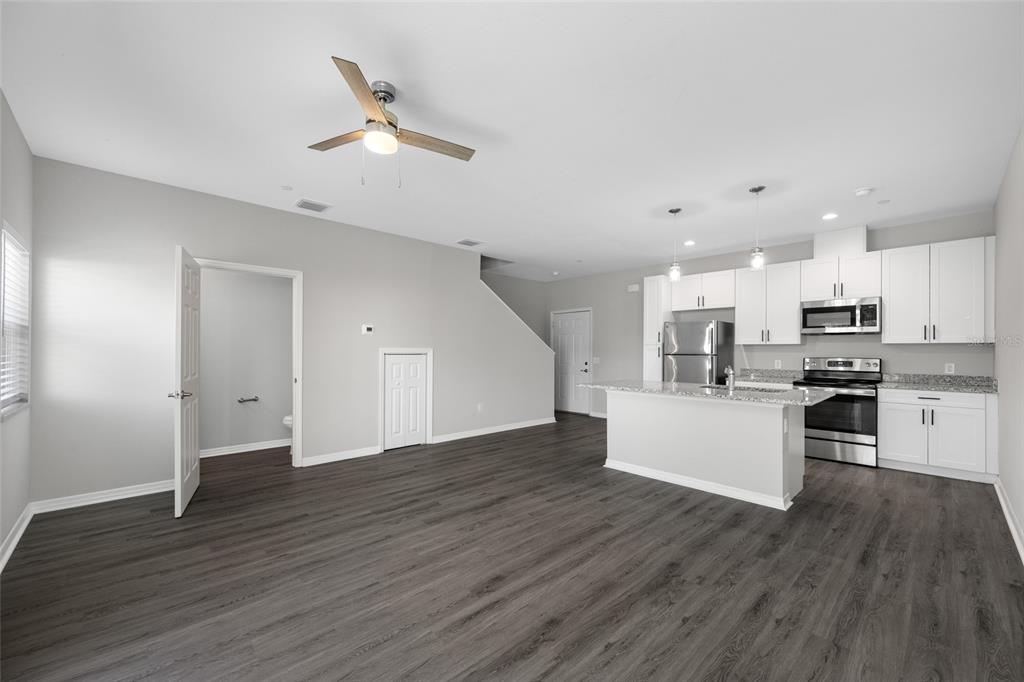 2115 Sebring Place Clearwater, FL 33760 - Photo 12 of 59 a kitchen with stainless steel appliances kitchen island wooden floors and view living room