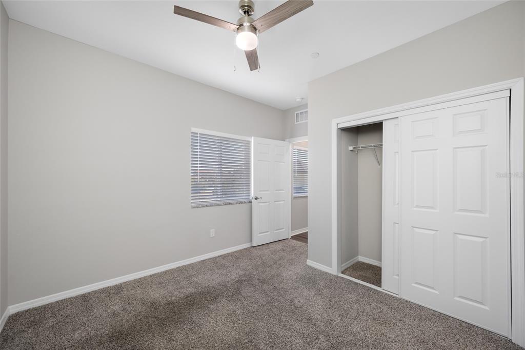 2115 Sebring Place Clearwater, FL 33760 - Photo 29 of 59 an empty room with a ceiling fan and carpet