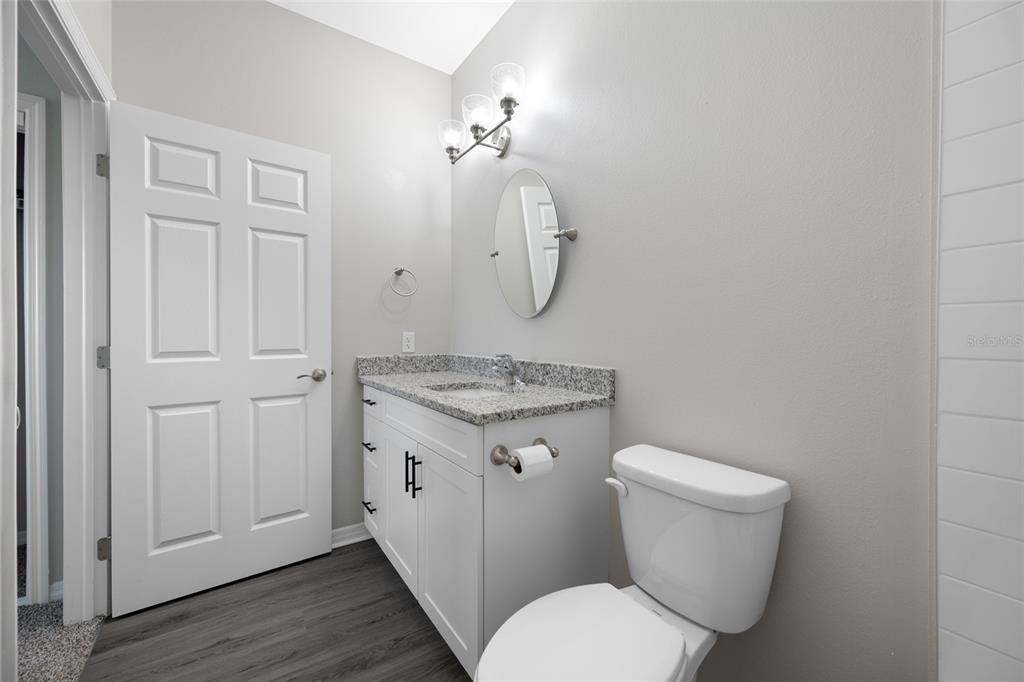2115 Sebring Place Clearwater, FL 33760 - Photo 30 of 59 a bathroom with a granite countertop toilet sink and mirror