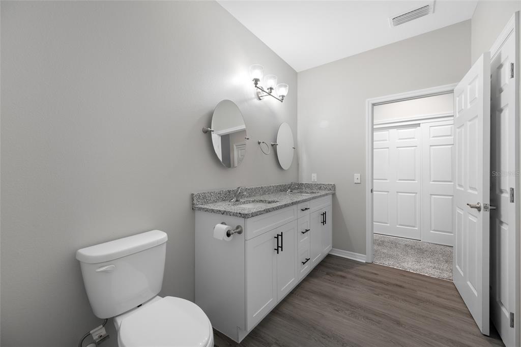 2115 Sebring Place Clearwater, FL 33760 - Photo 40 of 59 a bathroom with a granite countertop toilet sink and mirror