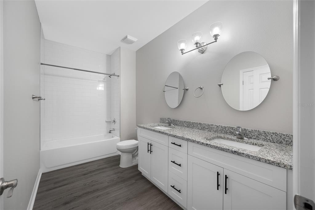 2115 Sebring Place Clearwater, FL 33760 - Photo 41 of 59 a spacious bathroom with a granite countertop sink a toilet a mirror and shower