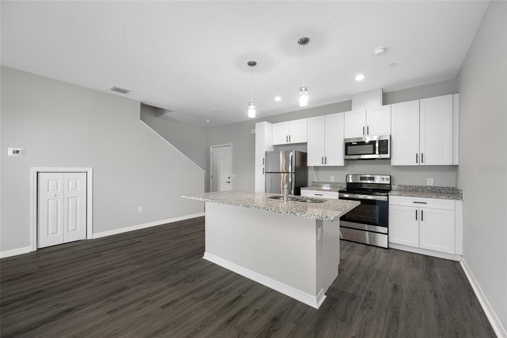 2115 Sebring Place Clearwater, FL 33760 - Photo 10 of 59 a kitchen with stainless steel appliances a stove top oven a sink a refrigerator cabinets and wooden floor