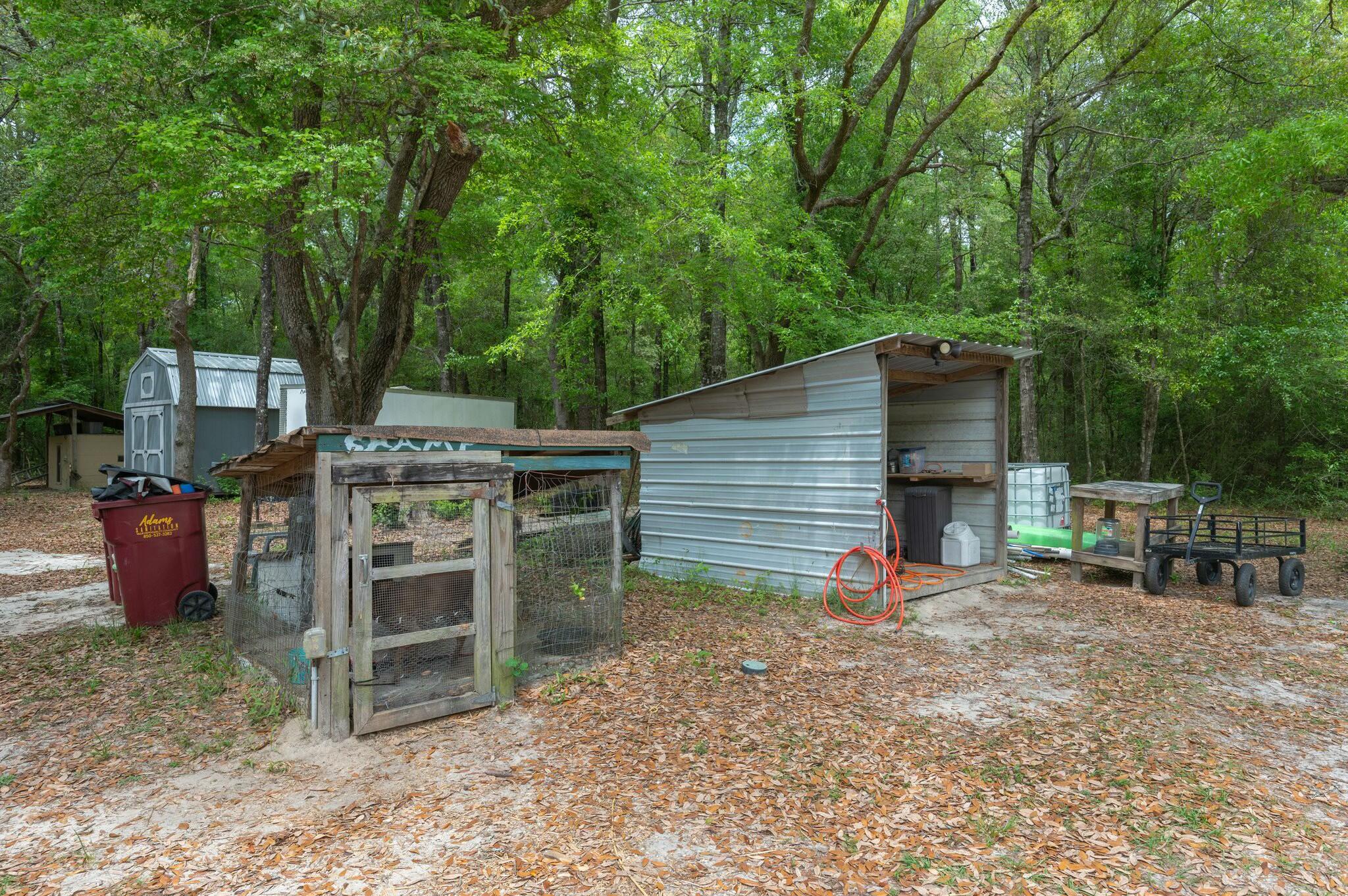 6188 Old River Road Baker, FL 32531 - Photo 22 of 34 a view of a backyard with table and chairs and a barbeque