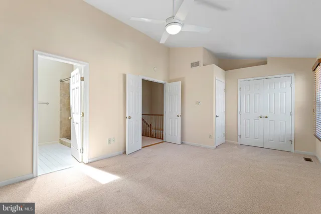 an empty room with closet and fan