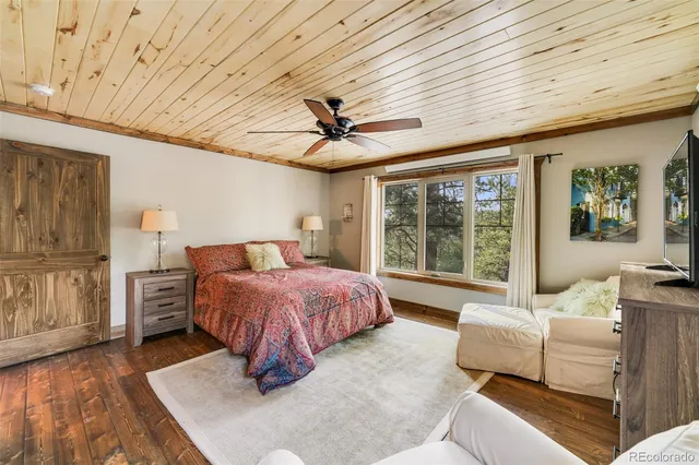 a spacious bedroom with a bed and glass walk in closet