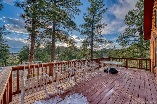 a balcony with wooden floor and outdoor seating