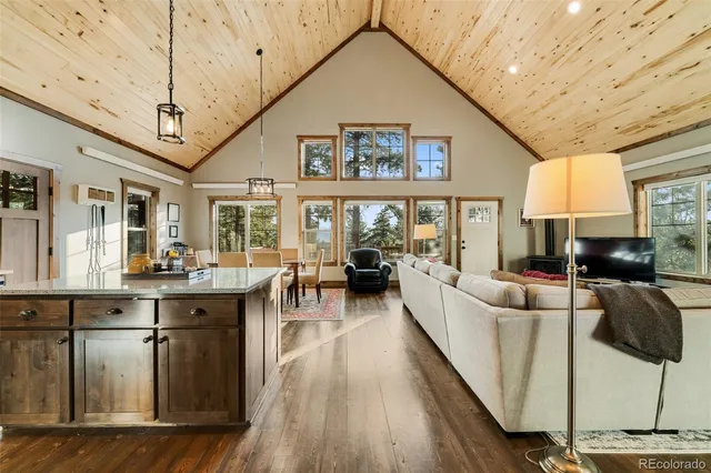 a living room with furniture a wooden floor and a large window