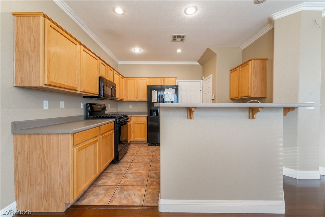 224 Positive Point Street Henderson, NV 89012 - Photo 12 of 44 Ample cabinetry and tile flooring define this functional kitchen workspace.