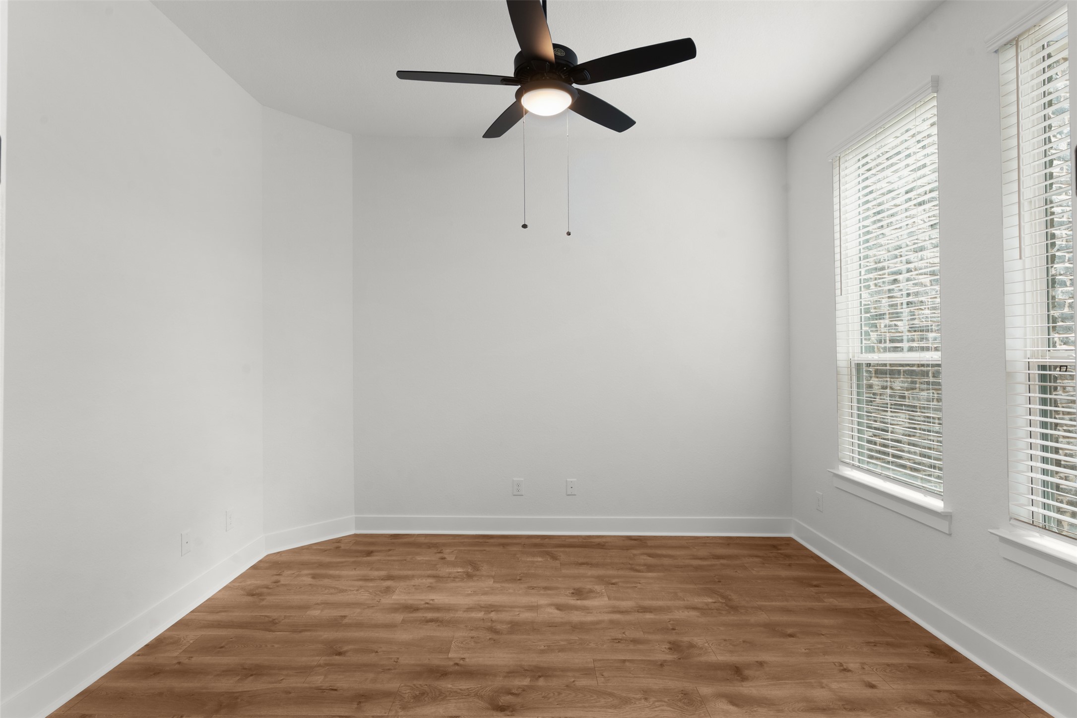 2312 Tobiano Trace Georgetown, TX 78633 - Photo 8 of 33 Open room featuring wood-finish flooring, white baseboards, and bright white walls