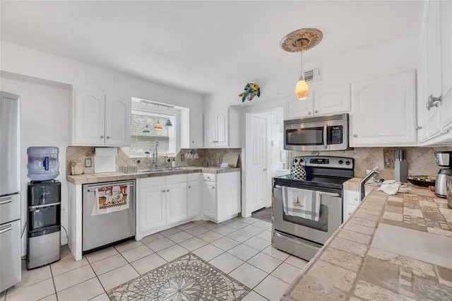 a kitchen with stainless steel appliances granite countertop a sink and cabinets