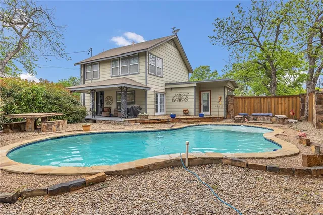 a view of a house with swimming pool and porch