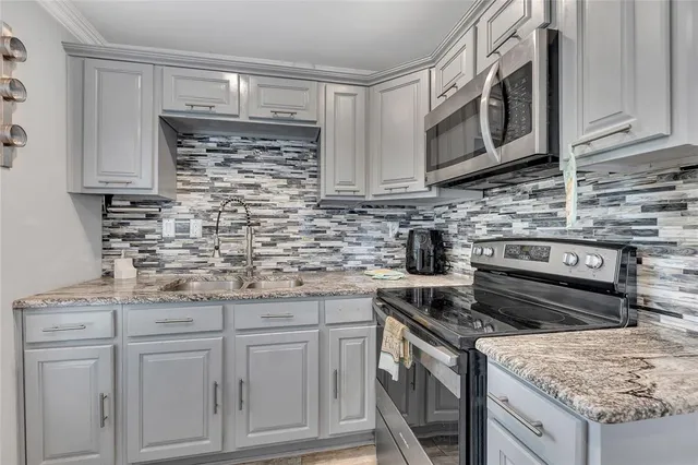 a kitchen with stainless steel appliances granite countertop a stove a sink and a microwave