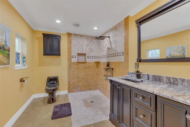 a spacious bathroom with a granite countertop sink a toilet a mirror and shower