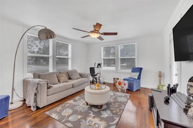 a living room with furniture a flat screen tv and a large window