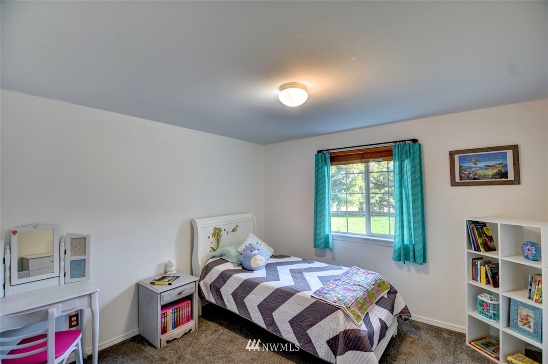 5124 183rd Lane Southwest Rochester, WA 98579 - Photo 18 of 31 a bedroom with a bed a dresser and a book shelf