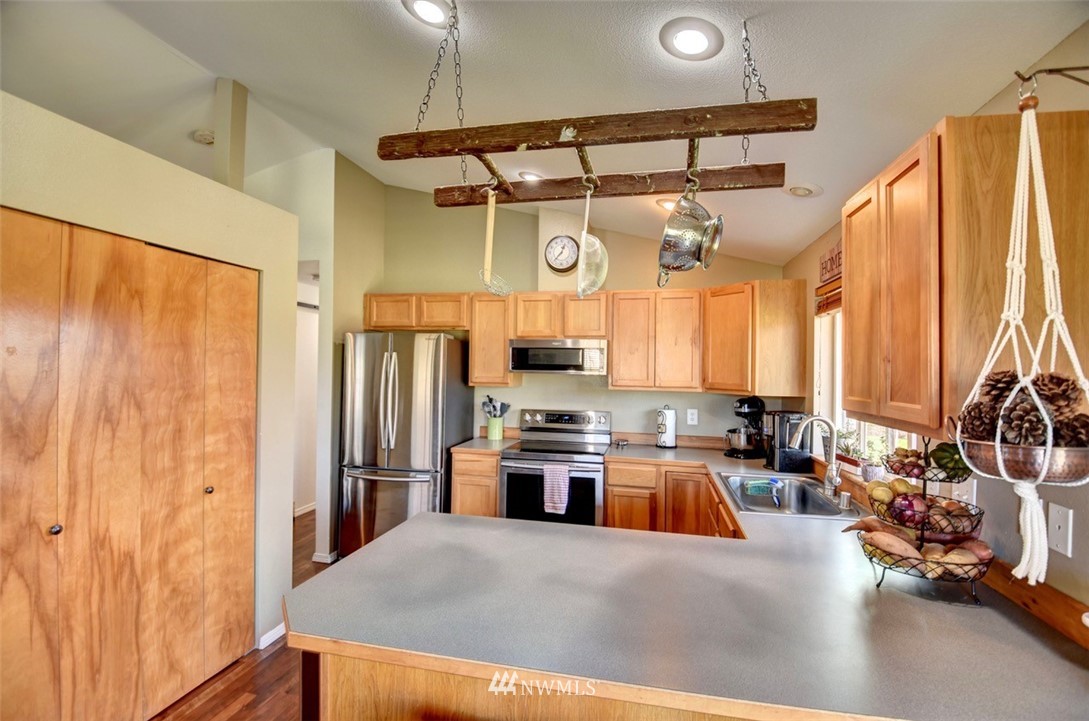 5124 183rd Lane Southwest Rochester, WA 98579 - Photo 5 of 31 a kitchen with a refrigerator a stove and a sink with wooden floor