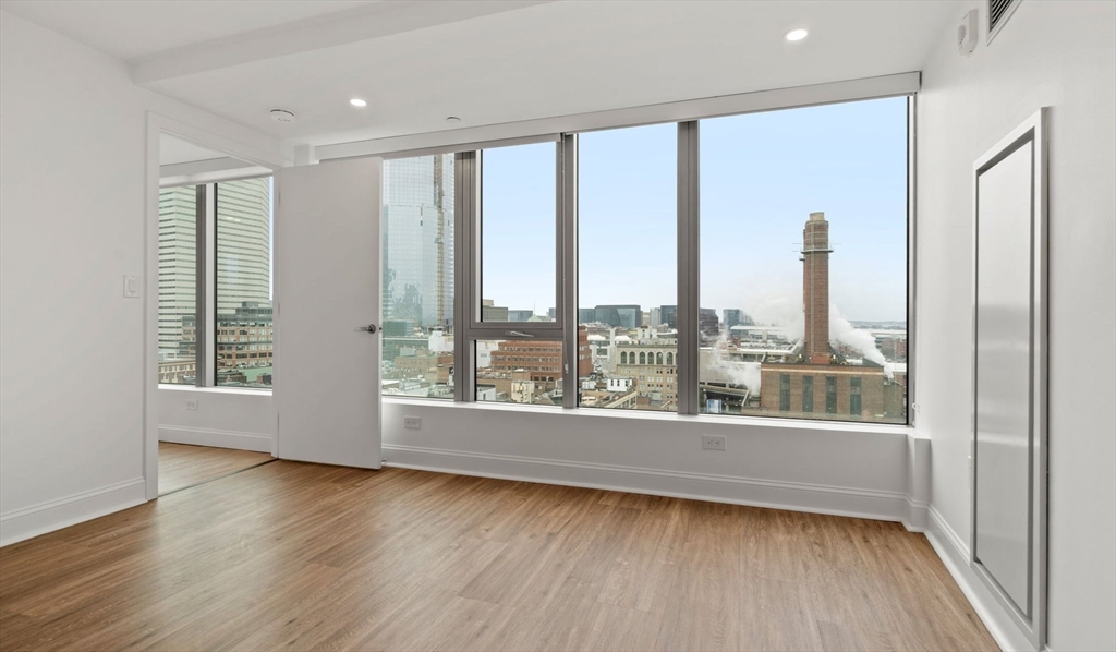 99 Kneeland Street, Unit 1908 Boston, MA 02111 - Photo 4 of 12 a view of a room with wooden floor and windows