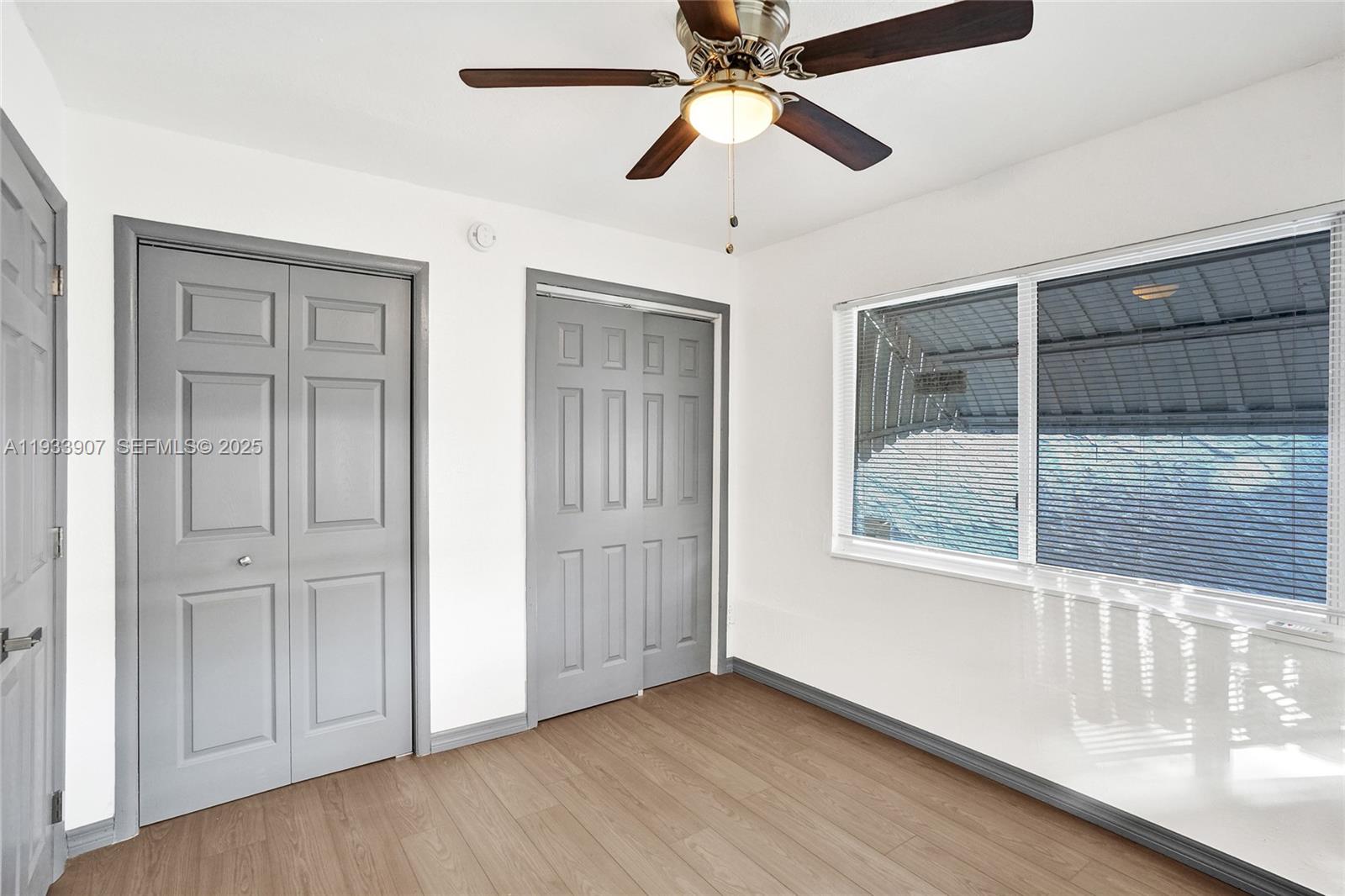 249 Southwest 4th Street, Unit 2 Dania Beach, FL 33004 - Photo 16 of 26 an empty room with wooden floor fan and windows