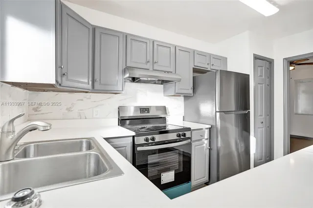 a kitchen with cabinets and stainless steel appliances